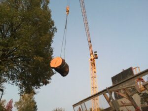 Une grue soulève un rondin suite à un abattage